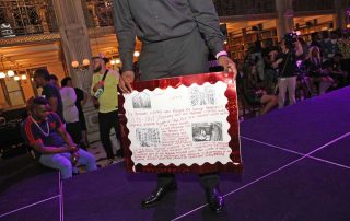 A performer holds a poster
