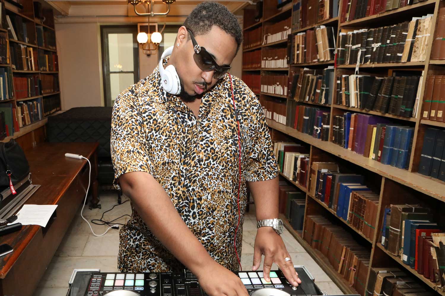 A DJ plays music with books behind them